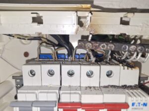 Vyhoretý bytový rozvádzač s roztavenou izoláciou vodičov a poškodenými ističmi. Havarijný stav elektroinštalácie v byte